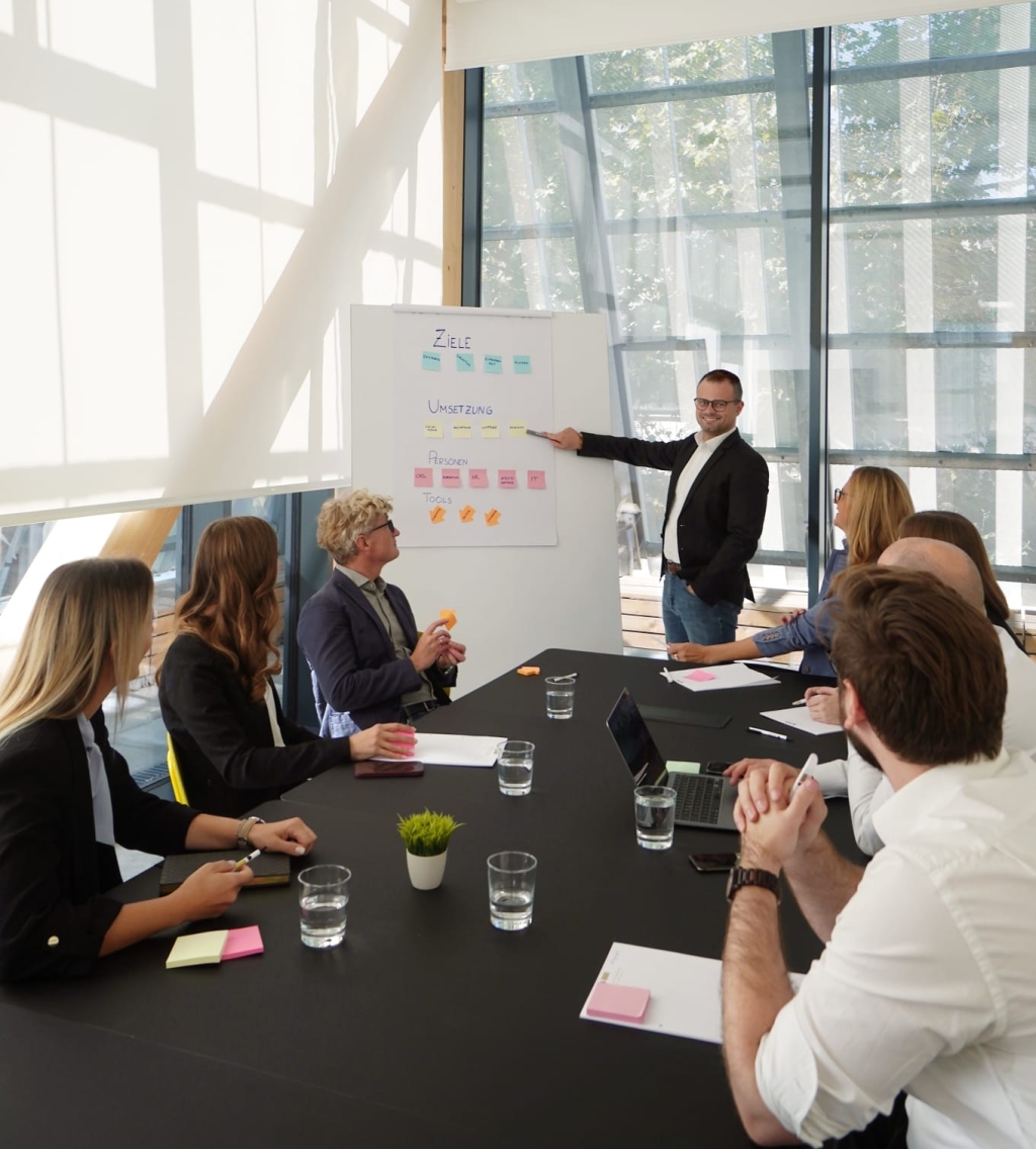 Mann steht am Flipchart und erklärt